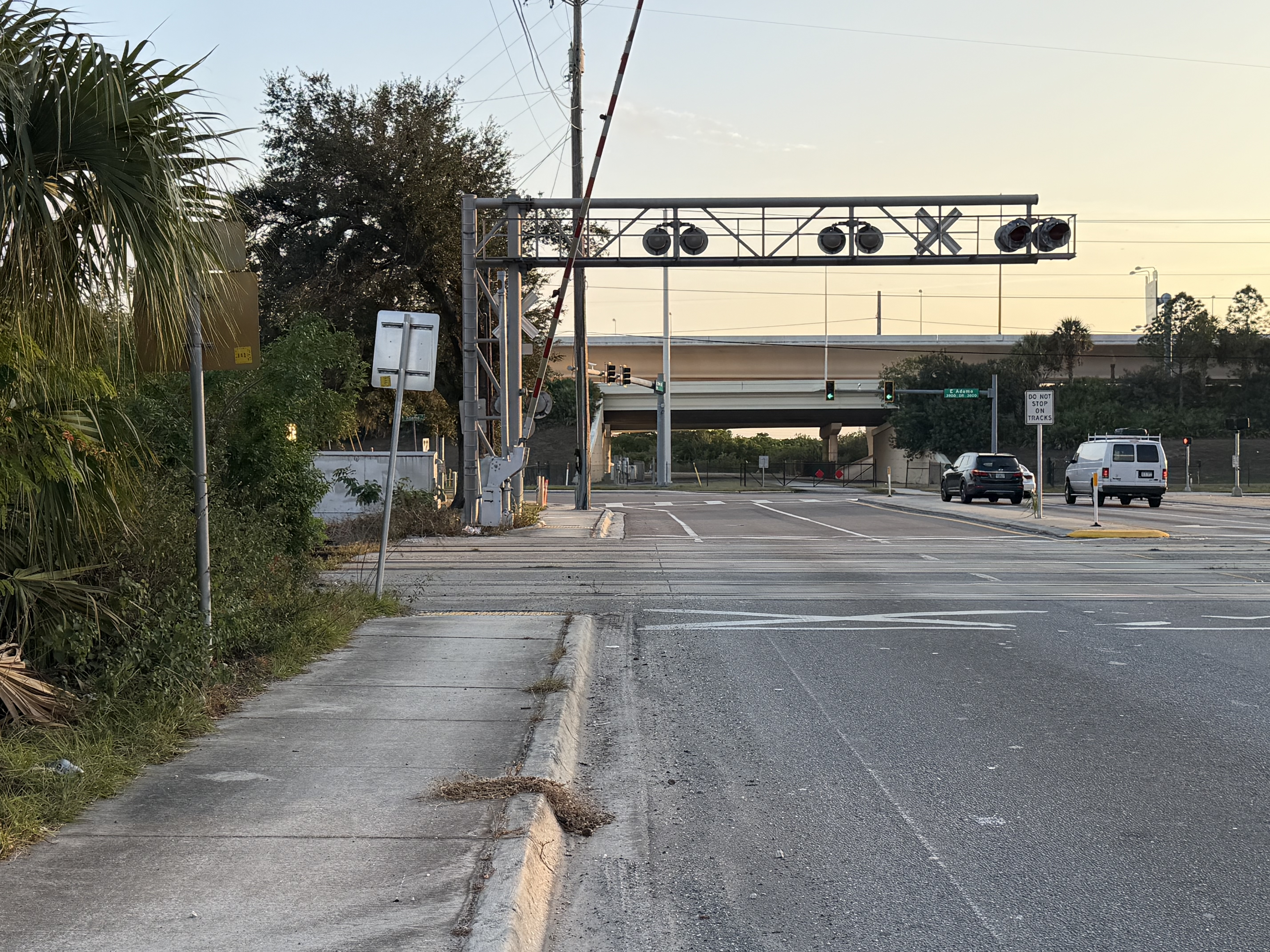 Grade crossing with cantilever signal, DO NOT STOP ON TRACKS sign, flashers and pedestrian sidewalk